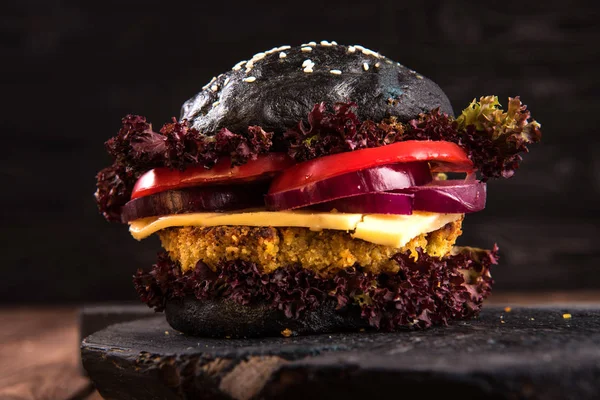 Schwarzer Burger auf dem Brett auf schönem rustikalem Holz-Hintergrund — Stockfoto