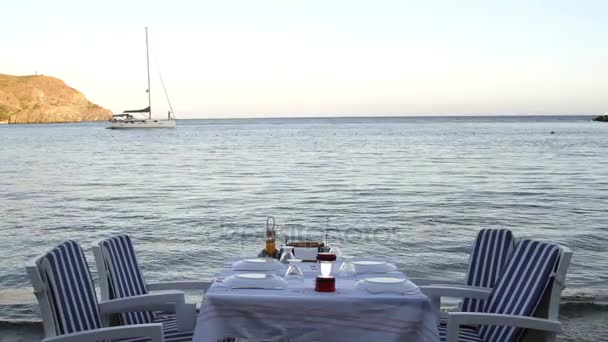 Middagsbord ved sjøen og seilbåt – stockvideo