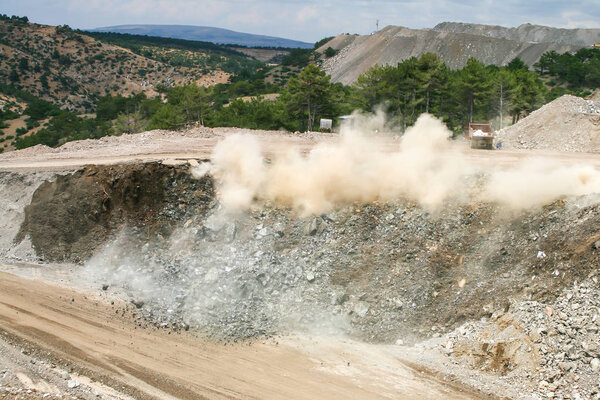  open cast mine after blast among dust and smoke