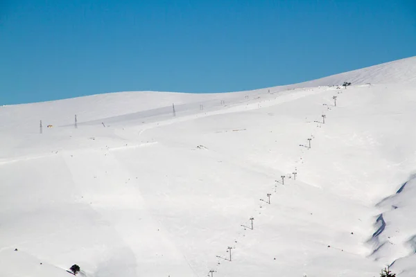 Лыжные трассы на фоне снежных гор и голубого неба — стоковое фото