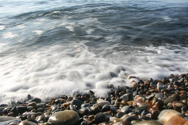 Espuma de olas de choque en la playa de piedra — Foto de Stock