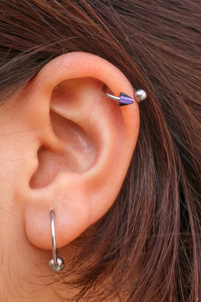 两只不同的耳环对着女士耳朵 免版税图库图片