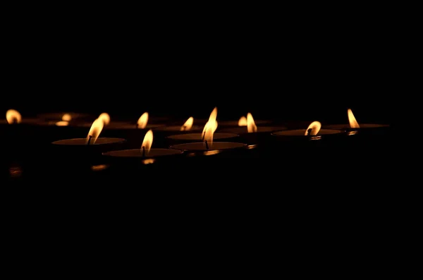 Piccole fiamme di candele al buio — Foto Stock