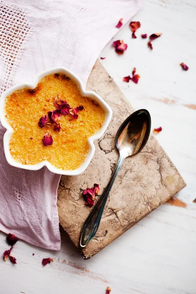 Creme brulee with edble pink roses — Stock fotografie