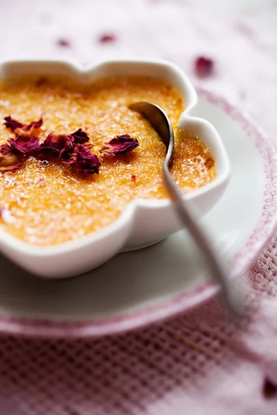 Creme brulee with edble pink roses — Stockfoto