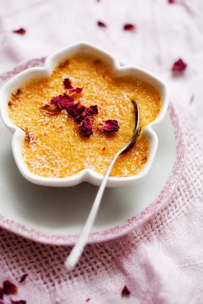 Creme brulee with edble pink roses — Stockfoto