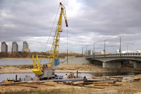 Jeřáb a trubky na zemi během opravy mostu — Stock fotografie