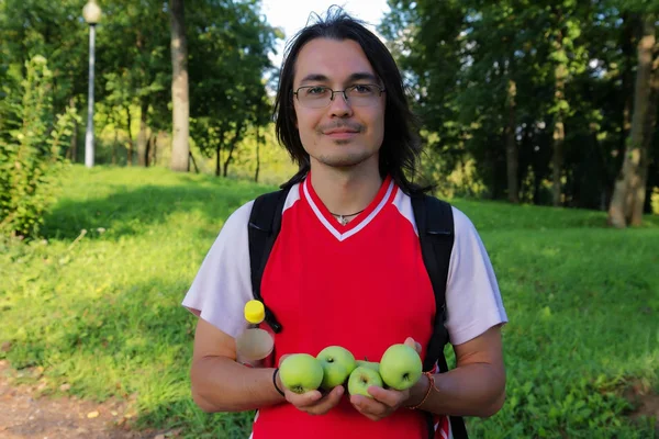Mladý muž v ruce držel jablka — Stock fotografie