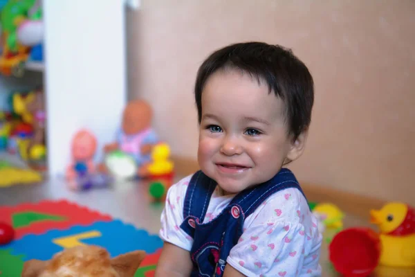 Bonita criança de 1 ano com brinquedos em seu quarto — Fotografia de Stock