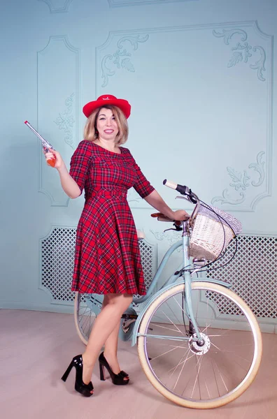 Beautiful woman cowgirl with shotgun standing near bicycle — Stock Photo, Image