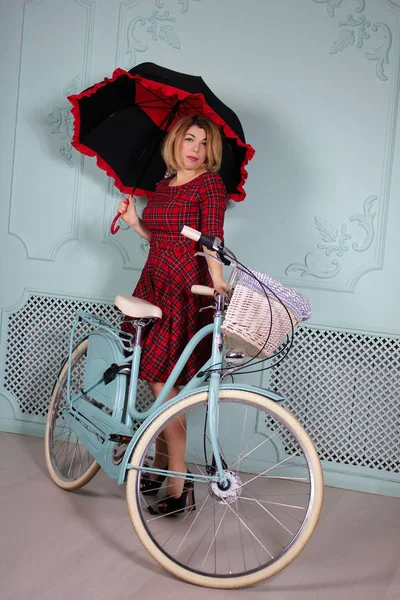 Schöne Frau mit Regenschirm, die neben Fahrrad steht — Stockfoto