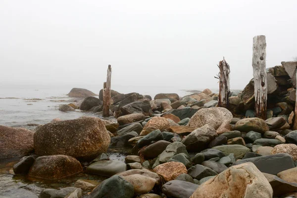 Rocks and Old Wooden Posts at the Bay — Stock Photo, Image
