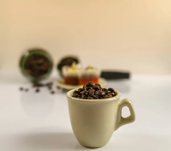 Pequeña taza cremosa de deliciosos granos de café — Foto de Stock