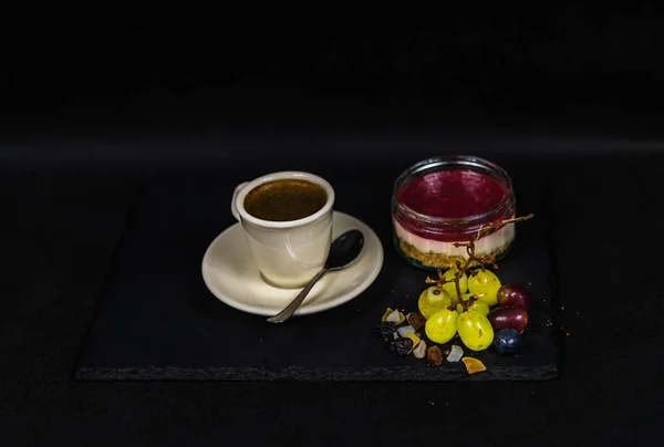 Café noir aromatique dans une tasse de crémeuse, douce desse fraise — Photo