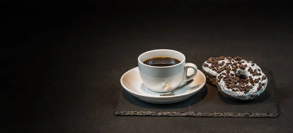 Ароматна чорна кава в білій чашці з двома орео пончиками на — стокове фото