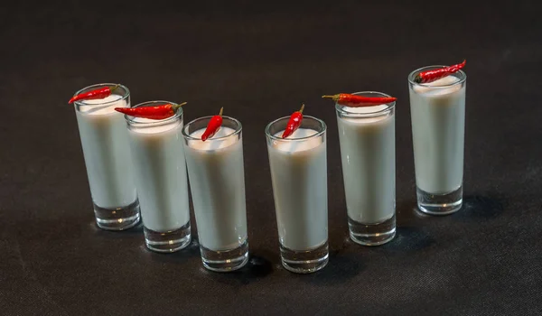 Seis bebidas de coco branco decorado com pimentas vermelhas, tudo em um bl — Fotografia de Stock