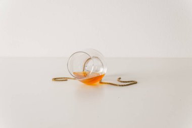 Beyaz, altın zincir ile devrilmiş tek malt viski camına