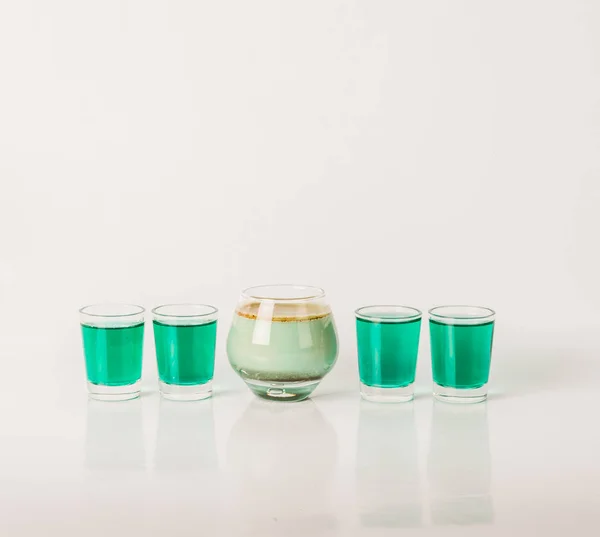 Cinco tiros de bebida de cor, diferentes formas de vidro, verde e pistola — Fotografia de Stock