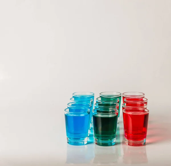 Gafas con kamikaze azul, verde y rojo, bebidas glamorosas, mezcla —  Fotos de Stock