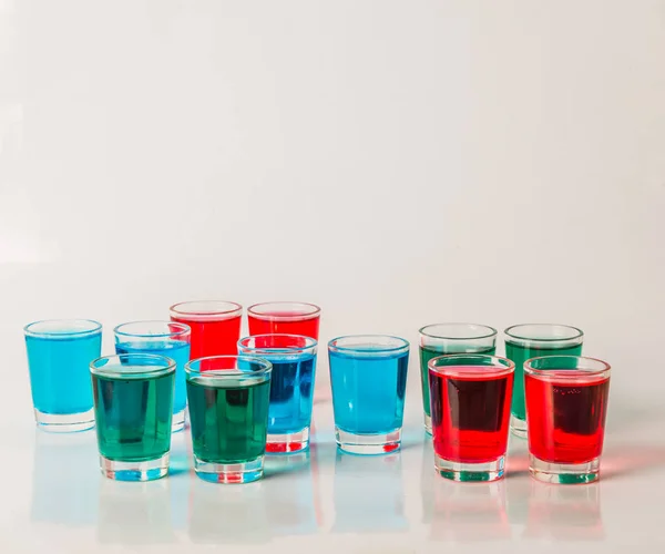 Glasögon med blå, gröna och röda kamikaze, glamorösa drycker, blanda — Stockfoto