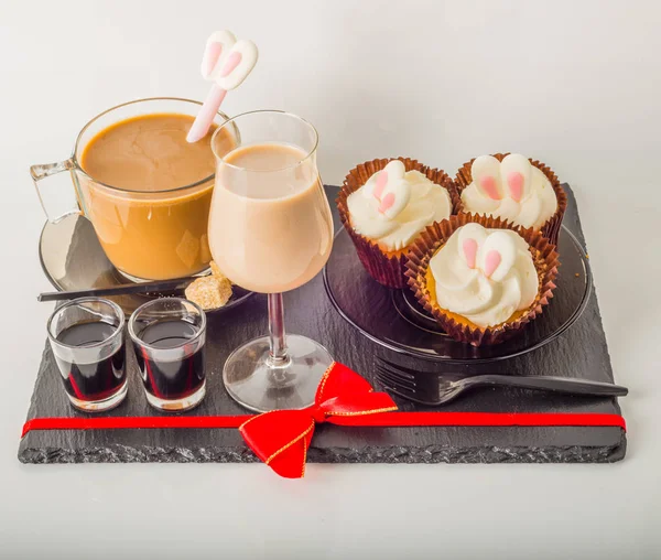 White coffee in modern glass cup, muffins with Easter decoration