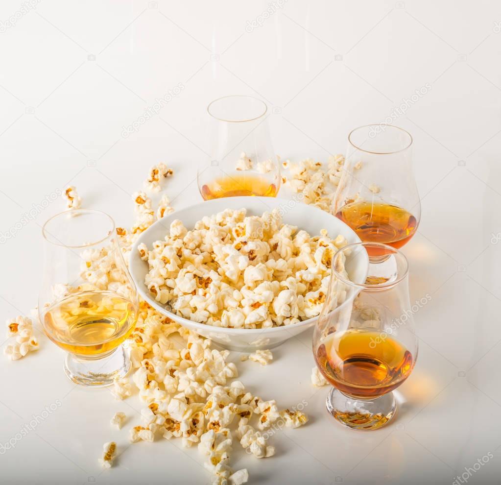 set of glasses of single malt whisky, salty popcorn in a bowl an