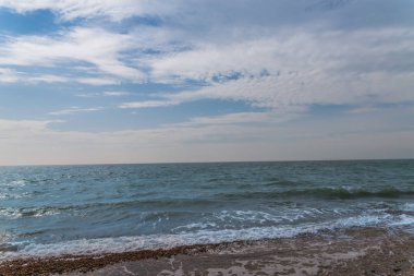 çakıl plaj ve okyanus, dalgalar ve mavi gökyüzü görünümü