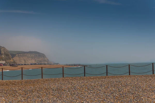 Vista da praia de seixos e do oceano, ondas e céu azul — Fotografia de Stock