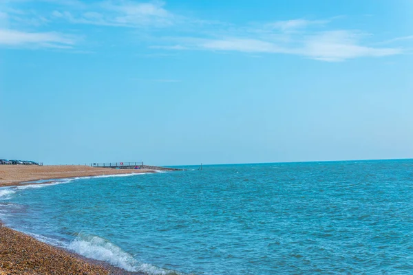 Vista de la playa de guijarros y el océano, olas y cielo azul —  Fotos de Stock