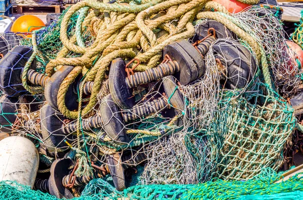 Velha corda desbotada deitada na costa em um porto de pesca, indústria eq — Fotografia de Stock