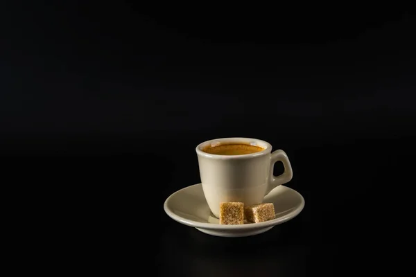 Café negro aromático en una taza blanca, azúcar morena, backgrou negro — Foto de Stock