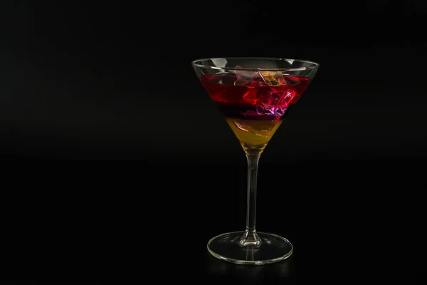 Барвистий напій у коктейльному келиху, з кубиками льоду, літній напій — стокове фото