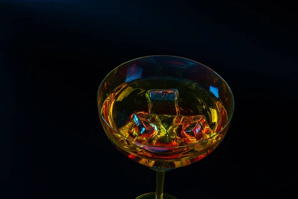 Kolorowy napój w kieliszku koktajlowym, z kostkami lodu, napój lato — Zdjęcie stockowe
