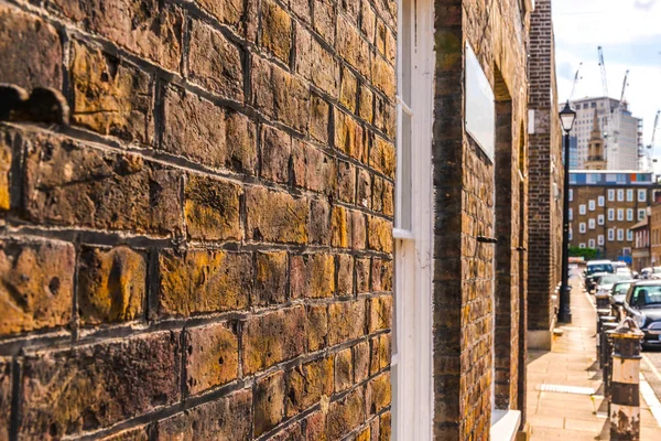 Typical old English buildings, low brick buildings across a narr