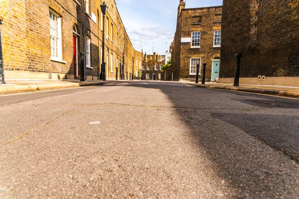 Edifícios ingleses velhos típicos, edifícios baixos do tijolo através de um narr — Fotografia de Stock