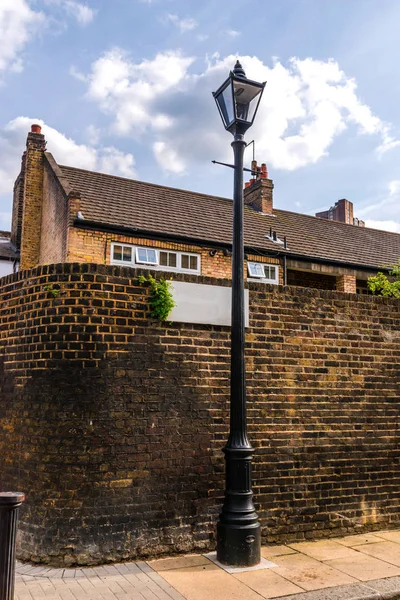 Edifícios ingleses velhos típicos, edifícios baixos do tijolo através de um narr — Fotografia de Stock