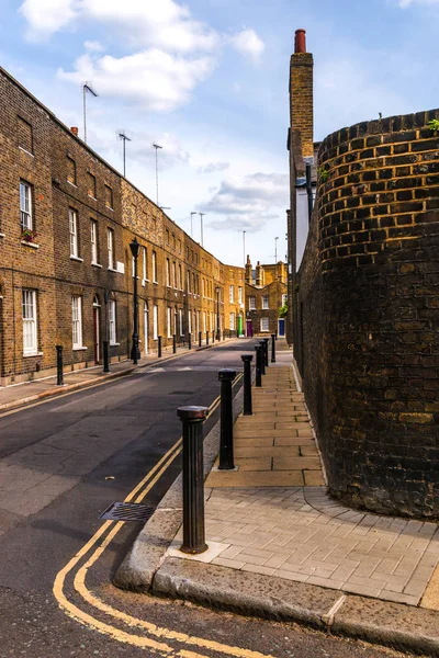 Typical old English buildings, low brick buildings across a narr