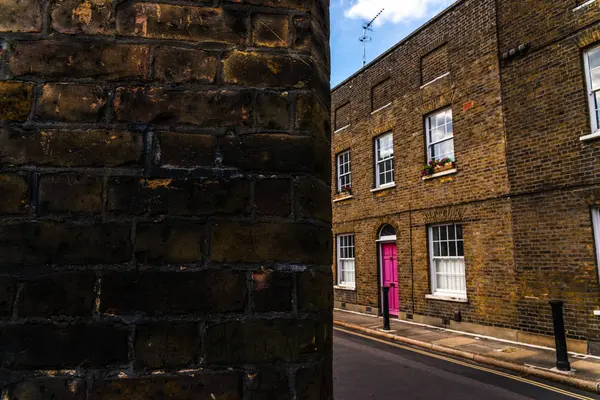 Edifícios ingleses velhos típicos, edifícios baixos do tijolo através de um narr — Fotografia de Stock