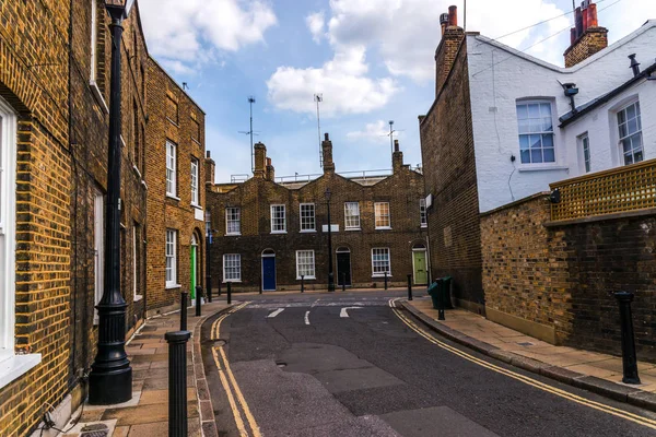 Edifícios ingleses velhos típicos, edifícios baixos do tijolo através de um narr — Fotografia de Stock