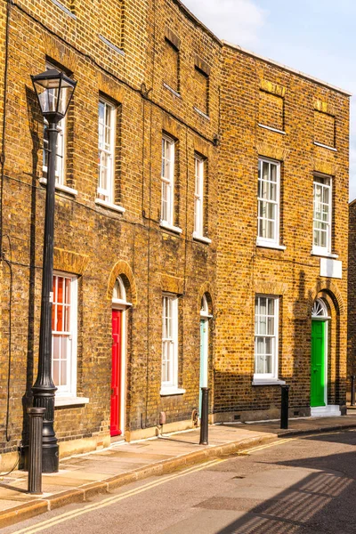 Typical old English buildings, low brick buildings across a narr