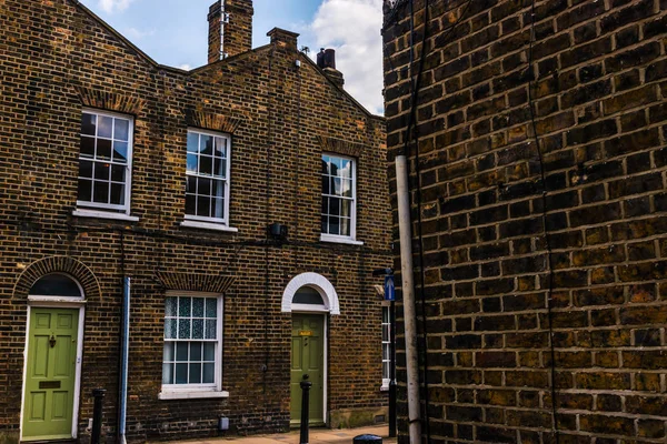 Typical old English buildings, low brick buildings across a narr