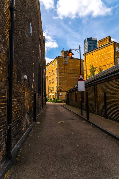 Edifícios ingleses velhos típicos, edifícios baixos do tijolo através de um narr — Fotografia de Stock