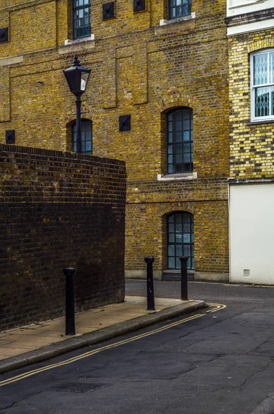 Edifícios ingleses velhos típicos, edifícios baixos do tijolo através de um narr — Fotografia de Stock