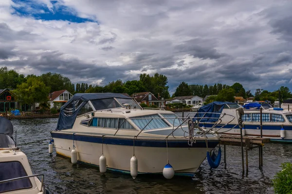 Bateaux ancrés sur la rive de la rivière, maisons résidentielles sur t — Photo