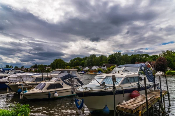 Bateaux ancrés sur la rive de la rivière, maisons résidentielles sur t — Photo