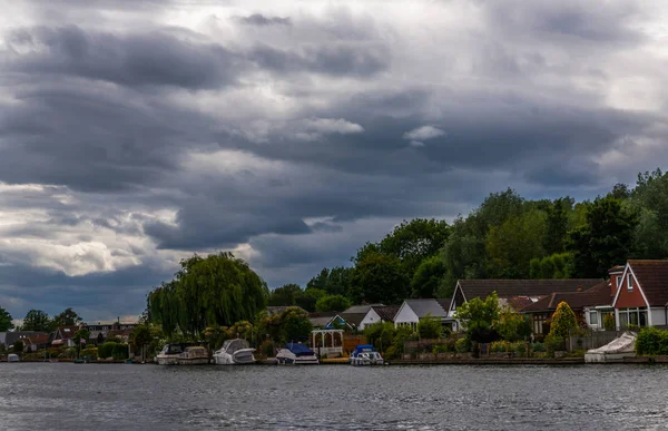 Large rivière et maisons sur le rivage, bateaux amarrés, végétati vert — Photo