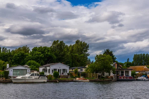 Large rivière et maisons sur le rivage, bateaux amarrés, végétati vert — Photo