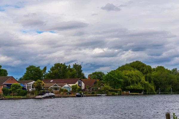 Large rivière et maisons sur le rivage, bateaux amarrés, végétati vert — Photo