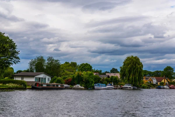 Large rivière et maisons sur le rivage, bateaux amarrés, végétati vert — Photo