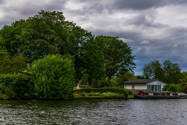 Large rivière et maisons sur le rivage, bateaux amarrés, végétati vert — Photo